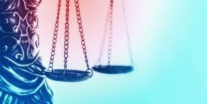 Photo of Justice scales with pink to blue gradient background